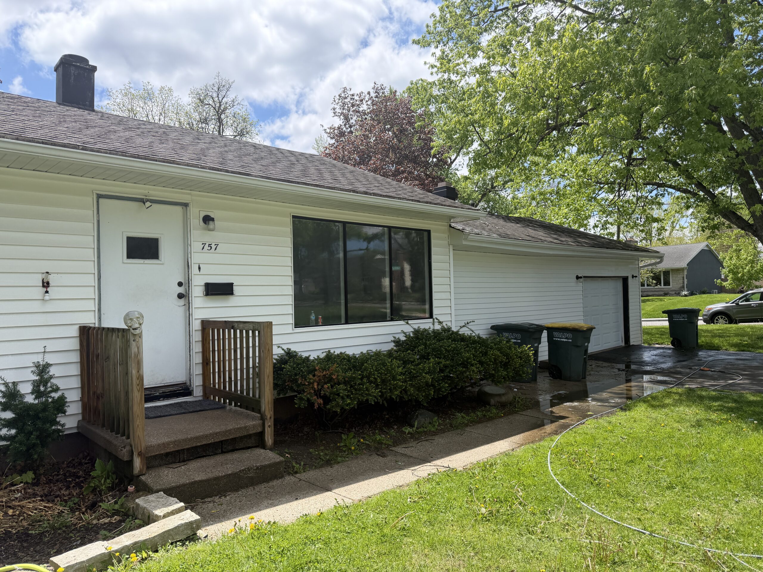 Skilled exterior cleaning technician adjusting soft wash process on delicate residential siding