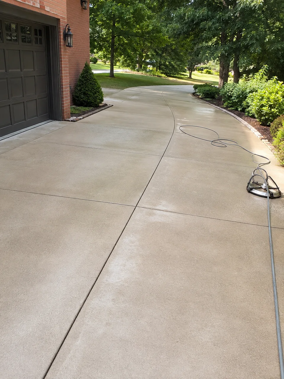 Specialist performing Concrete Cleaning beside a Valparaiso - IN walkway with visible surface grime removal